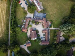 An areal shot of rural properties, surrounded by fields.